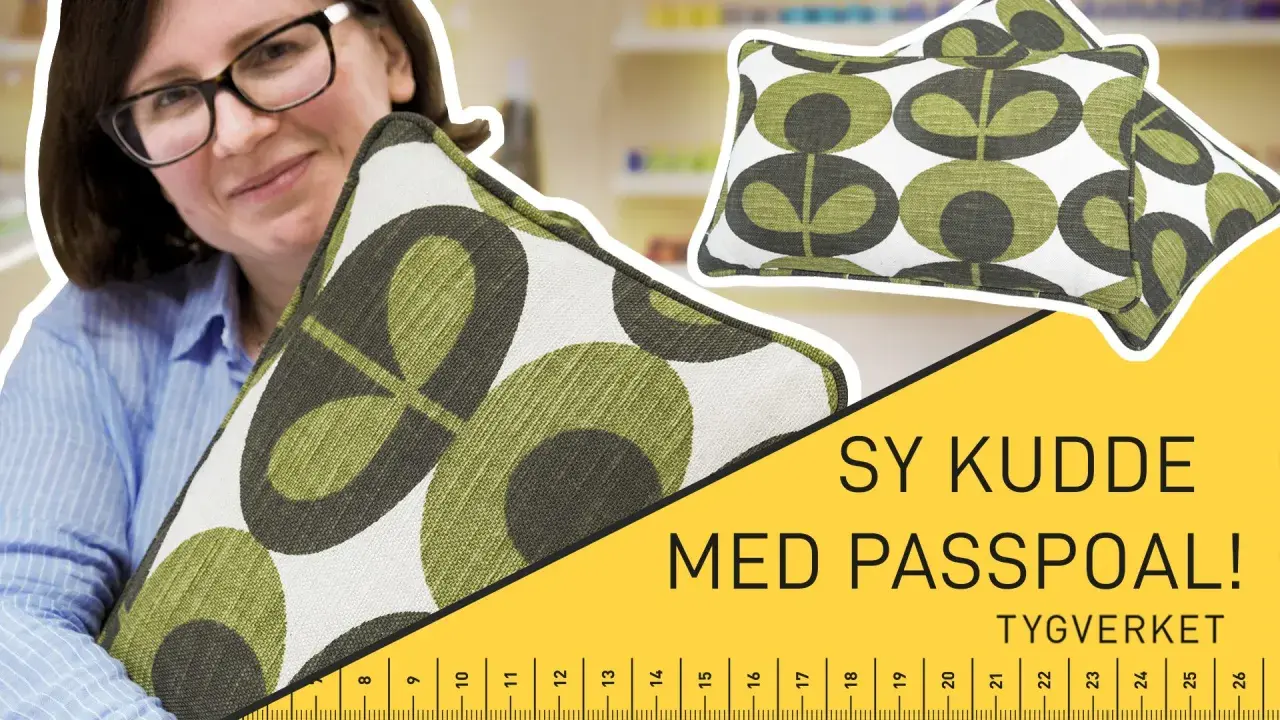 Kvinna med glasögon håller ett kuddfodral med grönt mönster. Texten "Sy kudde med passpoal!" syns.