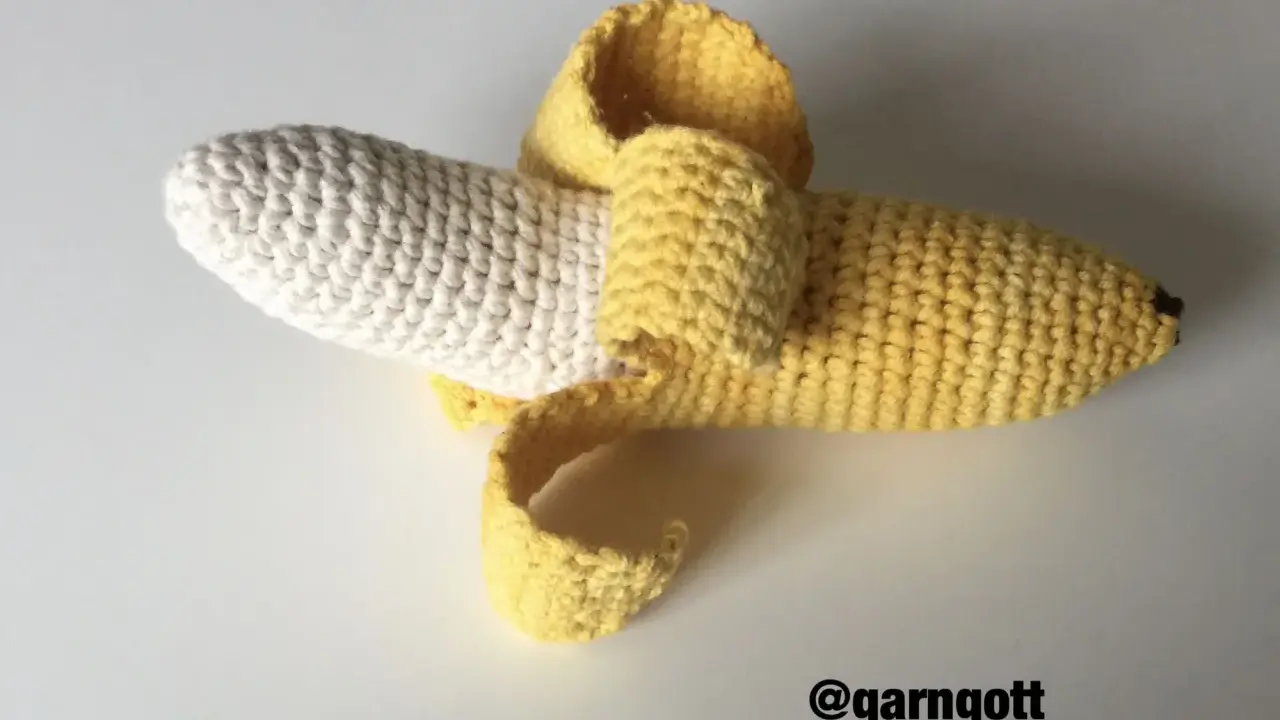 En virkad banan med skalet delvis avdraget. Den vita delen är bananen, och det gula är skalet.