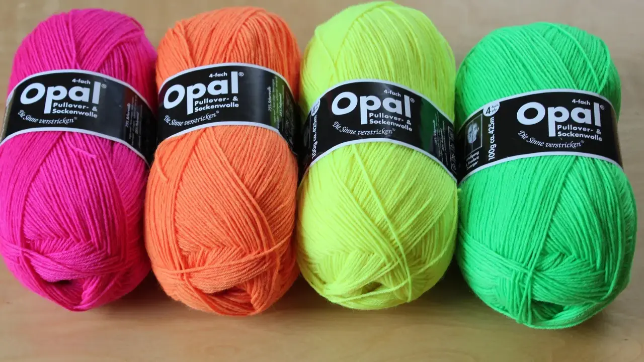 Four balls of Opal yarn in bright pink, orange, yellow, and green.