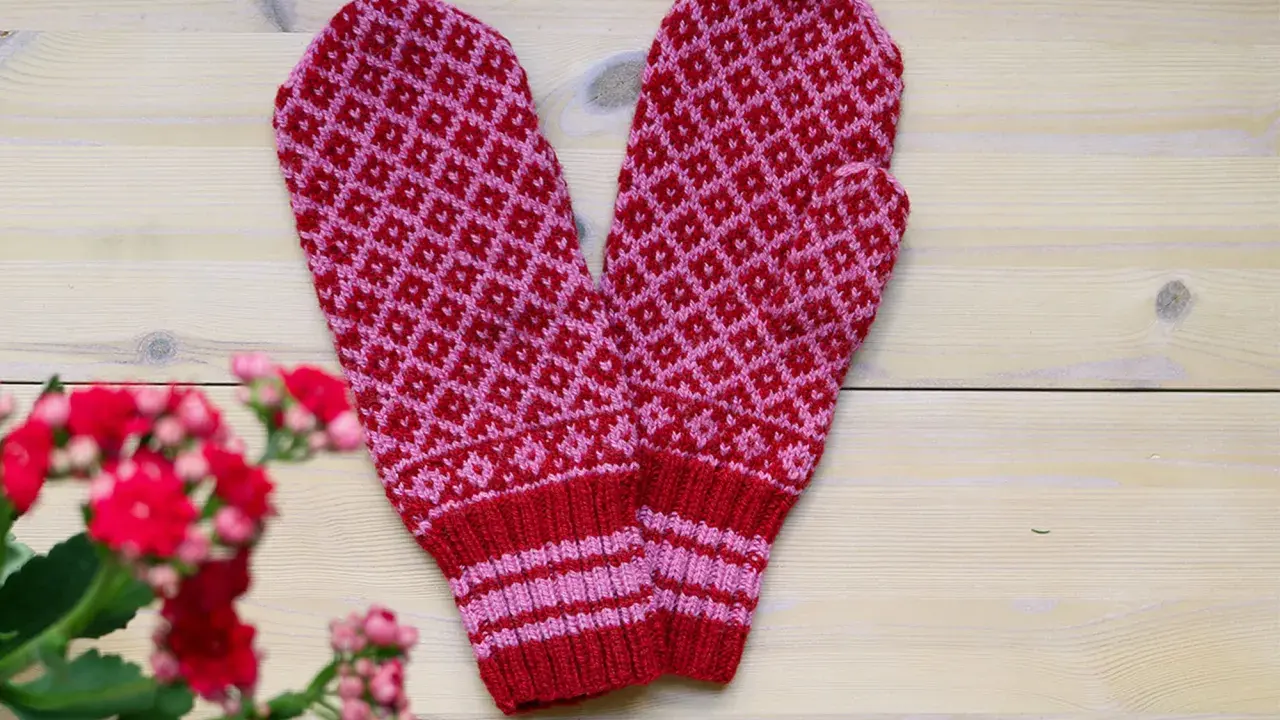 Två stickade vantar i rött och rosa med diamantmönster. Perfekt för dig som söker stickbeskrivningar gratis för att skapa egna.