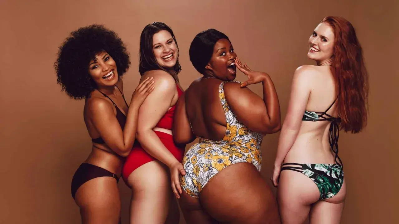 Fyra glada kvinnor i olika badkläder. En har en virkad bikini.