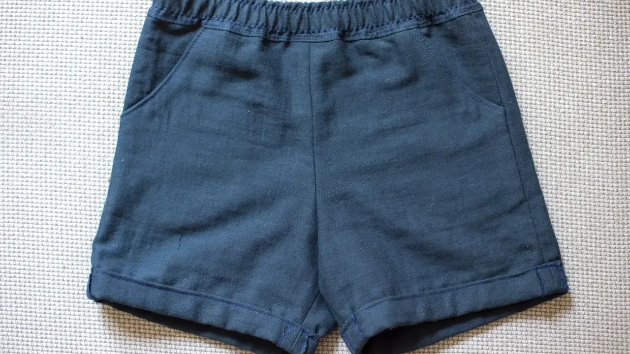 Mörkblå sy shorts med resår i midjan och fickor. Perfekta för lek och äventyr.