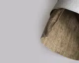 En rulle med canvas att måla på, med en grov, brunaktig baksida och en slätare, vitaktig framsida.