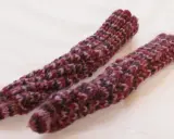 Två handstickade drops spiralsockor i ett melerat garn i vinröda och lila toner.