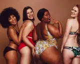 Fyra glada kvinnor i olika badkläder. En har en virkad bikini.