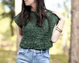 En kvinna bär en tjockstickad, grön slipover dam med jeans.