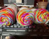 Three balls of brightly colored, variegated yarn sit on a keyboard.