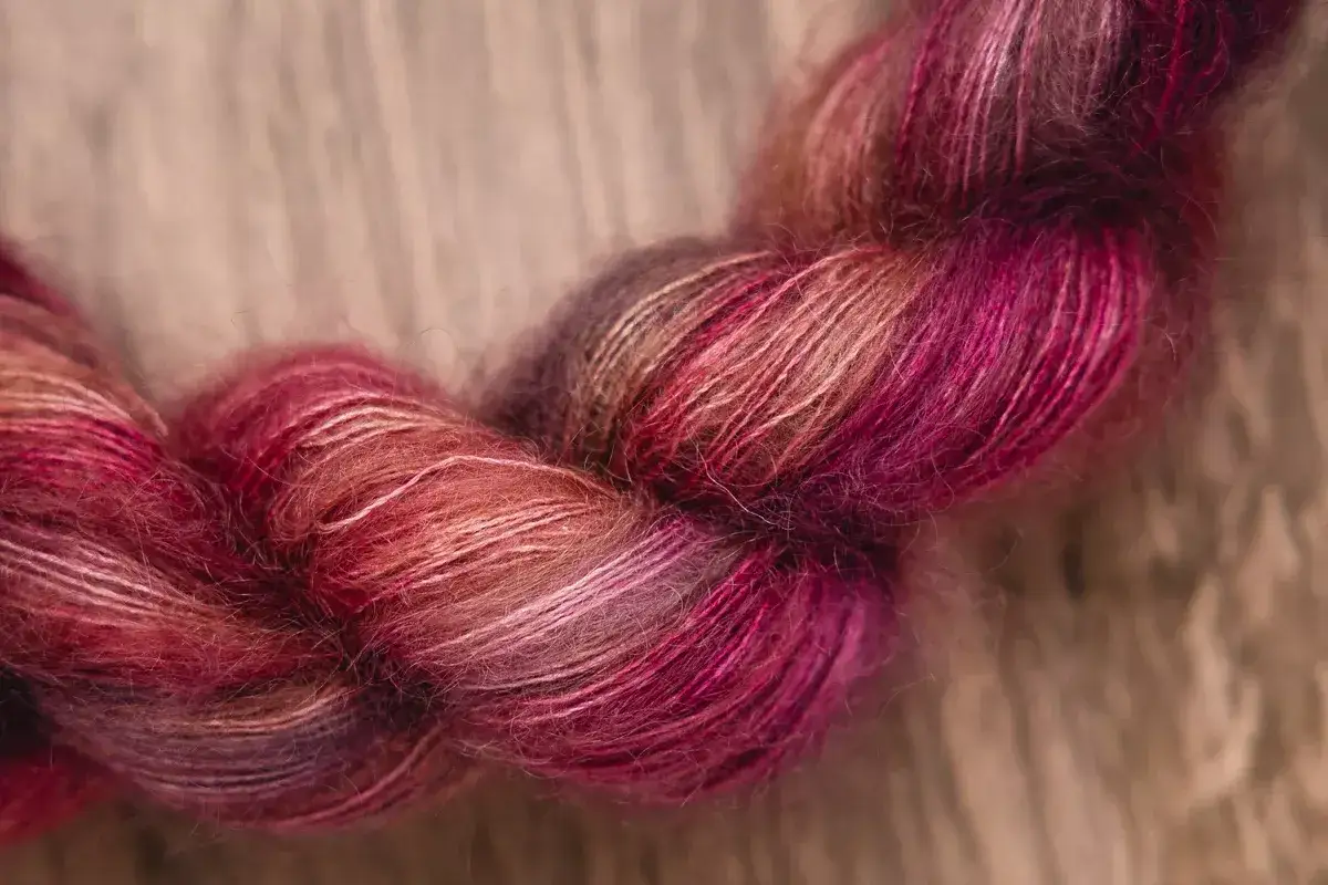 En h&auml;rva av mjukt mohair silke garn i varma rosa och lila toner, perfekt f&ouml;r en lyxig stickning.