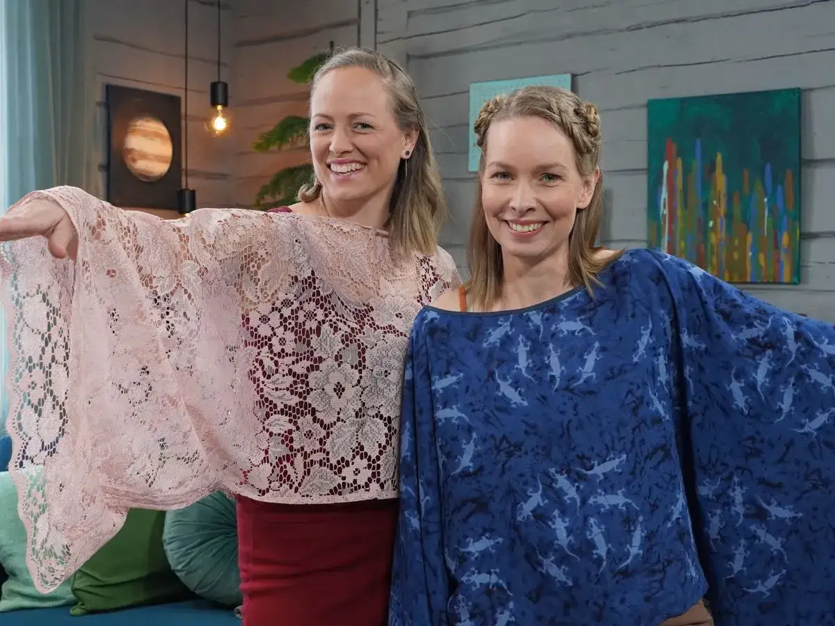 Tv&aring; glada kvinnor visar upp sina nya sy blusar. Den ena b&auml;r en ljusrosa spetsblus, den andra en m&ouml;rkbl&aring; med &ouml;dlem&ouml;nster.