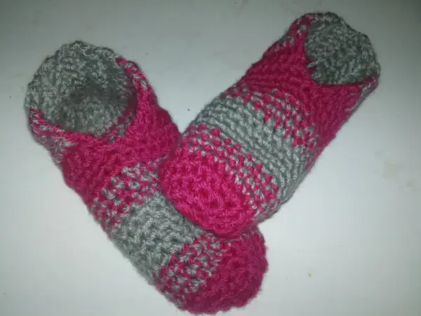 Ett par handvirkade tofflor i rosa och grått. Perfekta för mysiga hemmakvällar.
